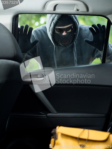 Image of Transportation crime concept .Thief stealing bag from the car
