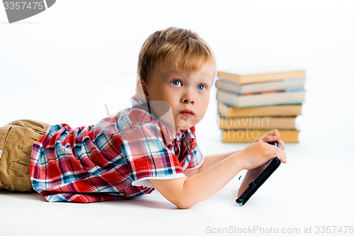 Image of small boy with tablet computer and books