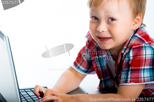 Image of little blue-eyed boy with a laptop