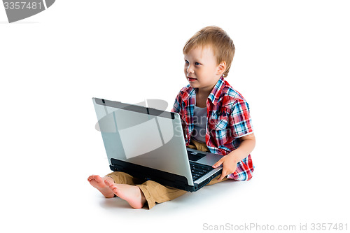 Image of little blue-eyed boy with a laptop on a white background