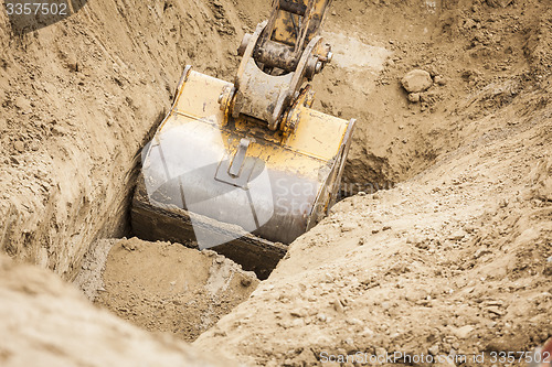 Image of Excavator Tractor Digging A Trench