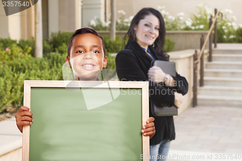 Image of Boy Holding Blank Chalk Board on Campus with Teacher Behind