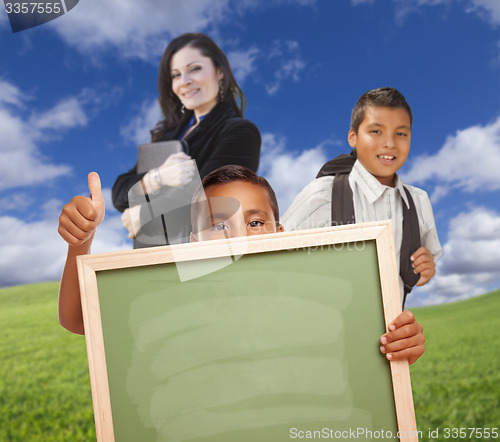 Image of Young Boys with Blank Chalk Board, Teacher Behind on Grass