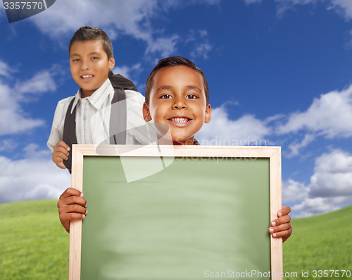 Image of Happy Hispanic Boys In Grass Field Holding Blank Chalk Board