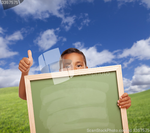 Image of Boy with Thumbs Up in Field Holding Blank Chalk Board
