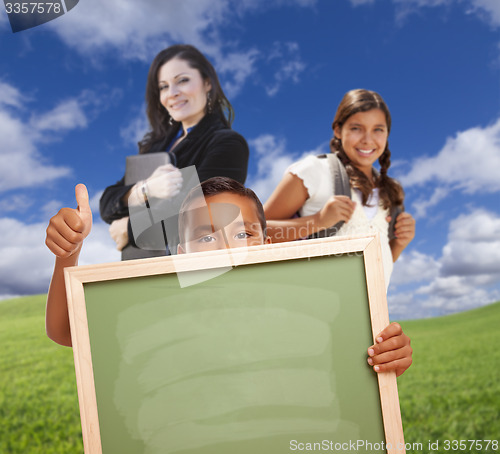 Image of Young Students with Blank Chalk Board, Teacher Behind on Grass