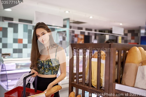 Image of young woman shopping in supermarket