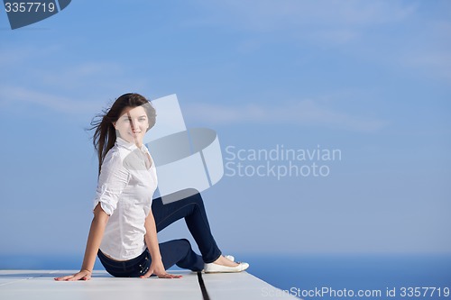 Image of relaxed woman in front of luxury modern home