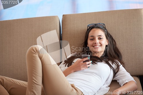 Image of young woman using cellphone at home