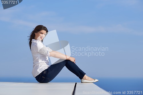 Image of relaxed woman in front of luxury modern home