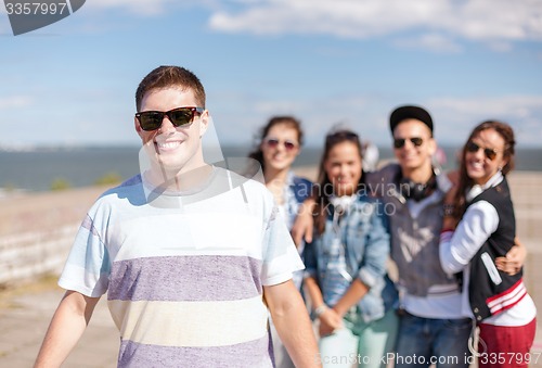 Image of teenage boy with sunglasses and friends outside