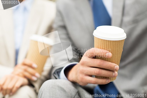 Image of close up of business people hands with coffee cups