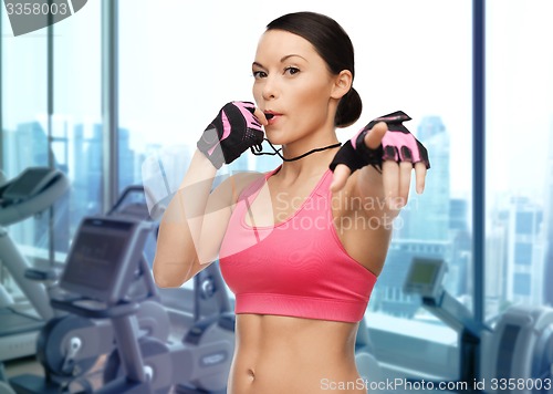 Image of asian woman coach blowing whistle over gym