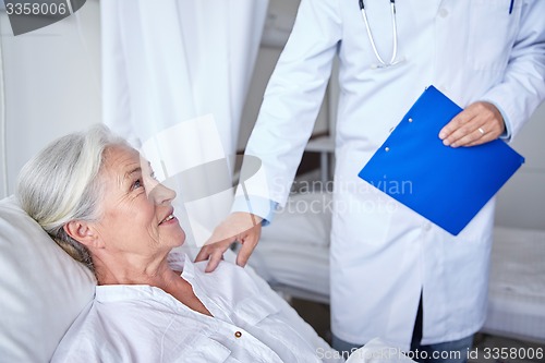 Image of doctor visiting happy senior woman at hospital