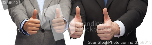 Image of businessman and businesswoman showing thumbs up