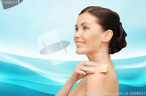 Image of woman with soap bar over blue wavy background