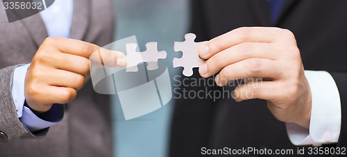 Image of businessman and businesswoman with puzzle pieces