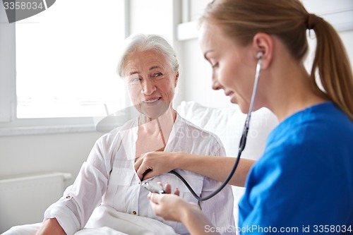 Image of nurse with stethoscope and senior woman at clinic