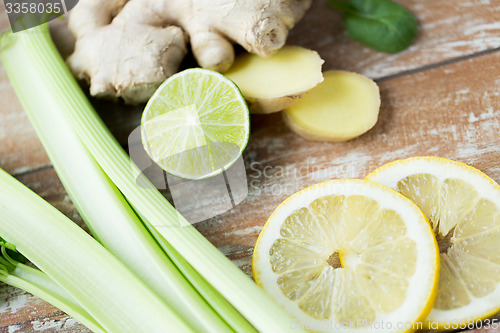 Image of close up of ginger, celery and lemon on table