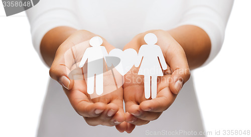 Image of womans hands with paper couple