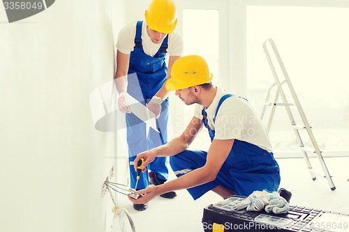 Image of builders with tablet pc and equipment indoors