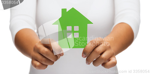 Image of woman hands holding green house