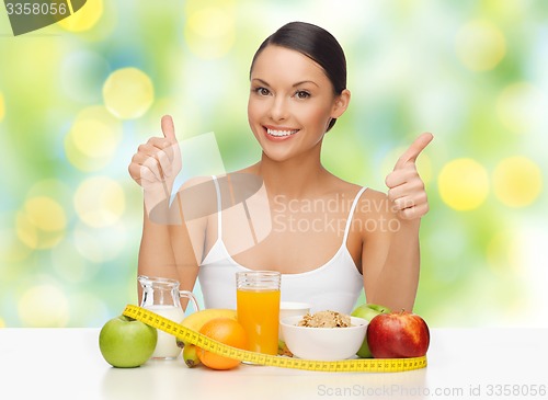 Image of happy woman with healthy food showing thumbs up