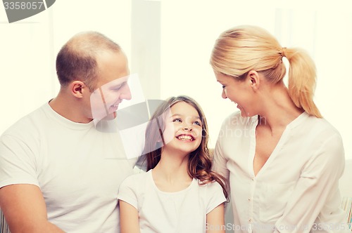 Image of smiling parents and little girl at home