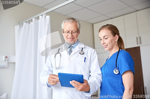 Image of senior doctor and nurse with tablet pc at hospital