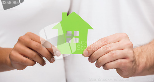 Image of couple hands holding green house