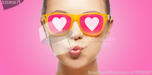 Image of girl in pink sunglasses blowing kiss