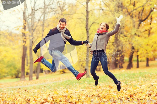 Image of smiling couple having fun in autumn park