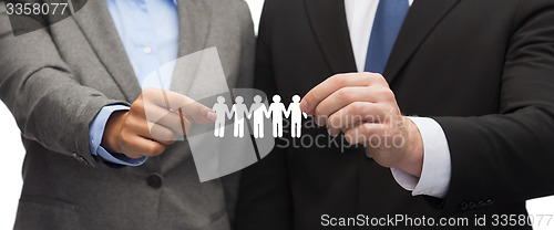 Image of businessman and businesswoman holding paper team