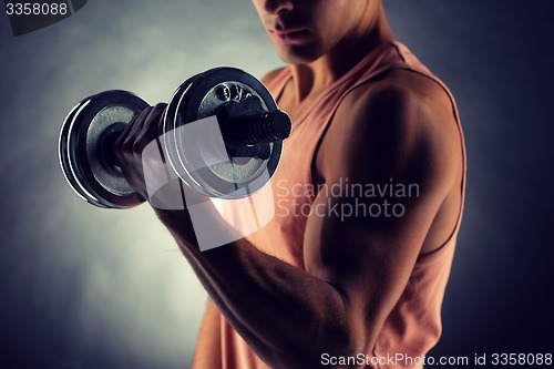 Image of close up of young man with dumbbell