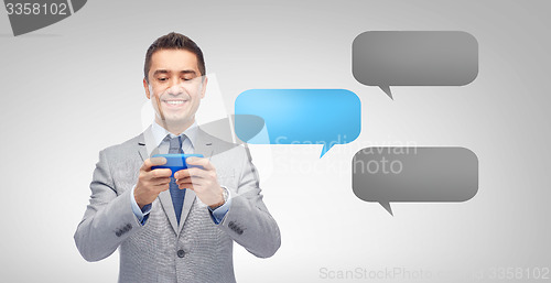 Image of happy businessman texting message on smartphone