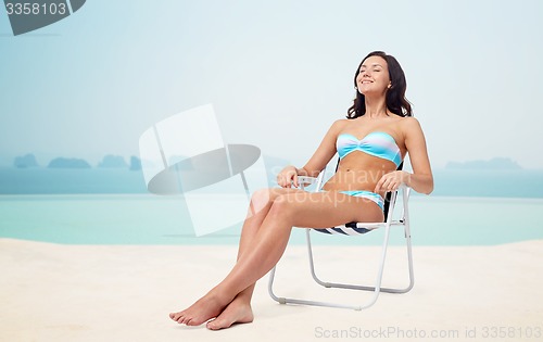 Image of happy young woman sunbathing in bikini swimsuit