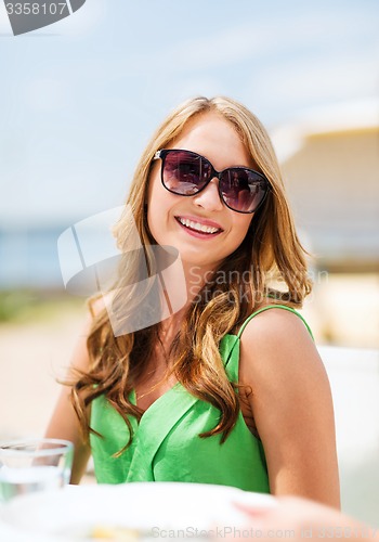 Image of girl in shades in cafe on the beach