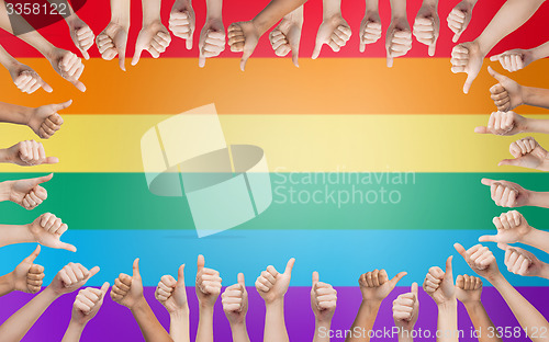 Image of hands showing thumbs up in circle over rainbow