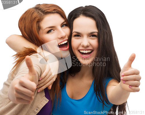 Image of two smiling girls showing thumbs up