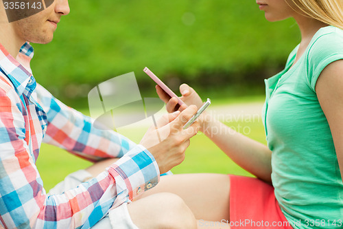 Image of close up of couple with smartphones outdoors