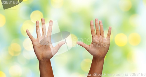 Image of african hands making high five over green lights