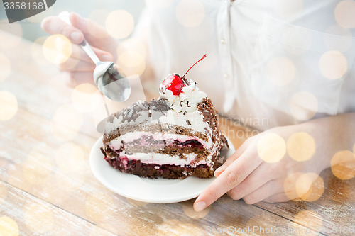 Image of close up of woman eating chocolate cherry cake