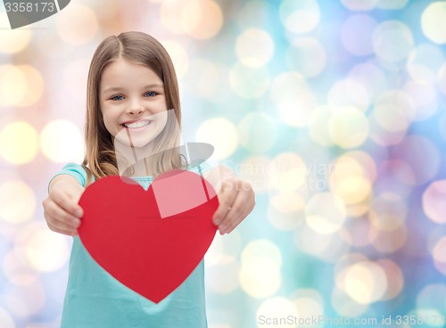 Image of smiling little girl giving red heart