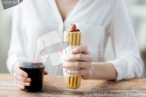 Image of close up of woman with hot dog and coca cola drink