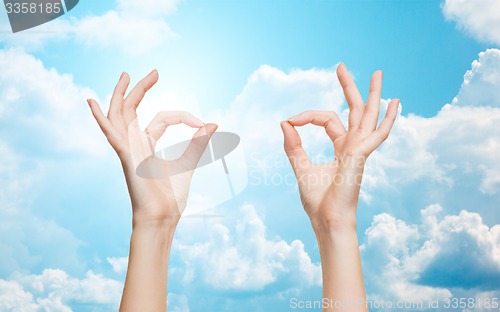 Image of woman hands showing ok sign over blue sky