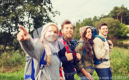 Image of group of smiling friends with backpacks hiking