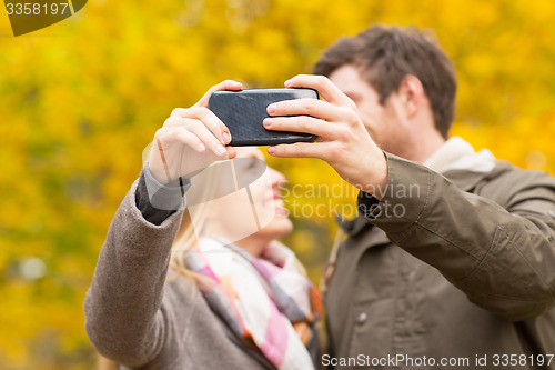 Image of couple taking selfie with smartphone in park