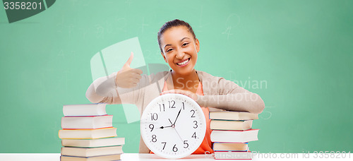 Image of african student girl with books and clock