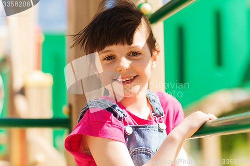 Image of happy little girl climbing on children playground