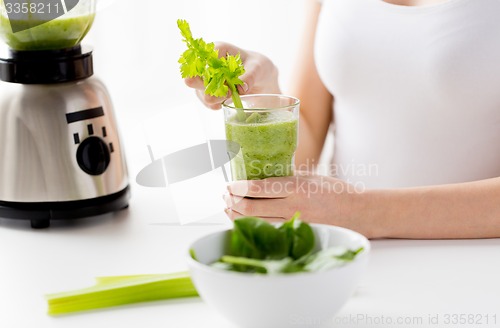 Image of close up of woman with blender and green smoothie